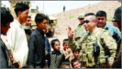 Image of a soldier engaged in conversation with a group of Afghanistan locals.